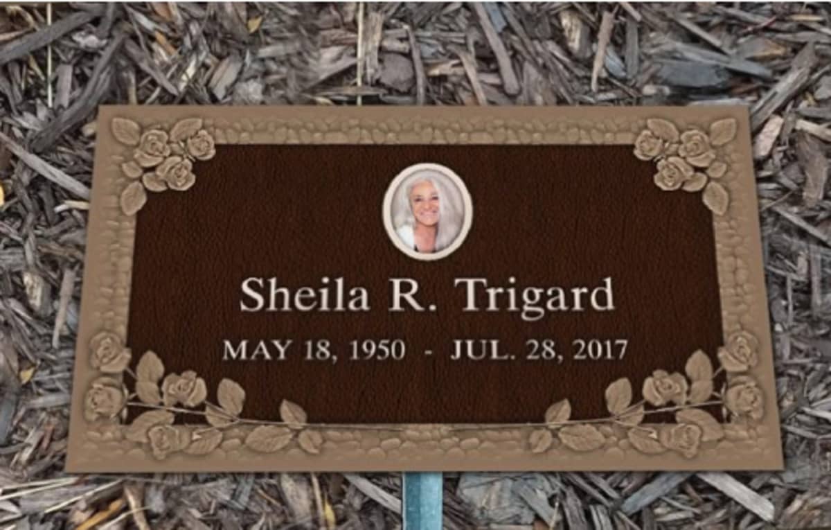 A grave marker with the name, date of birth and death, and picture